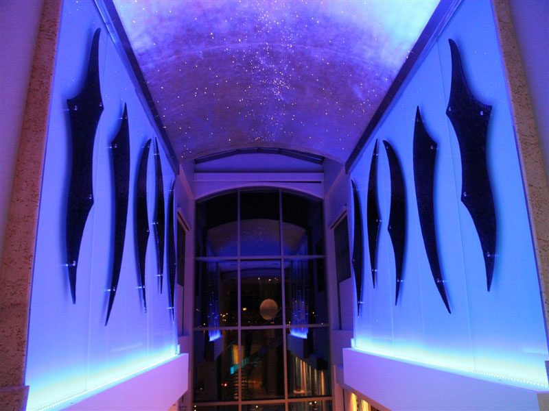 Architectural glass project. Decorative shaped, colored, textured glass sculptures attached to backpainted glass.